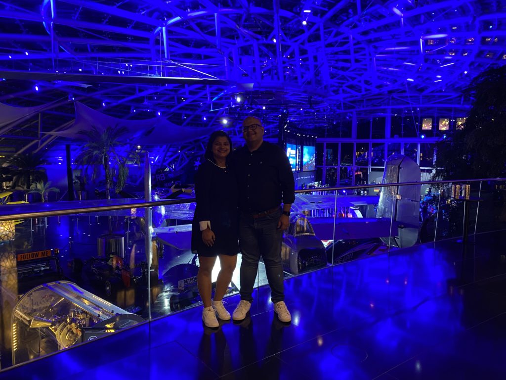 a man and woman standing in a room with blue lights