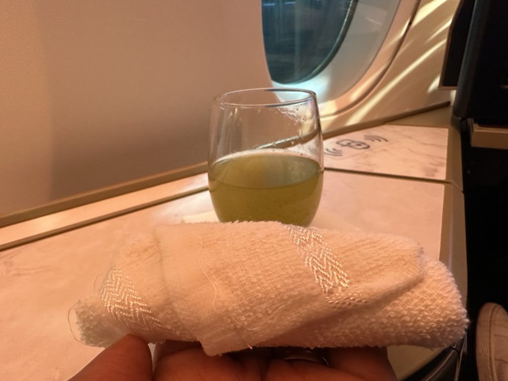a hand holding a towel and a glass of liquid