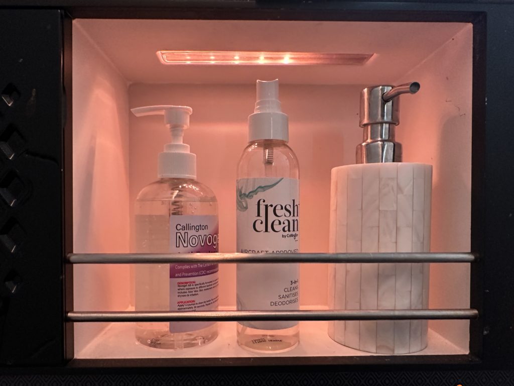 a shelf with bottles and soap dispensers