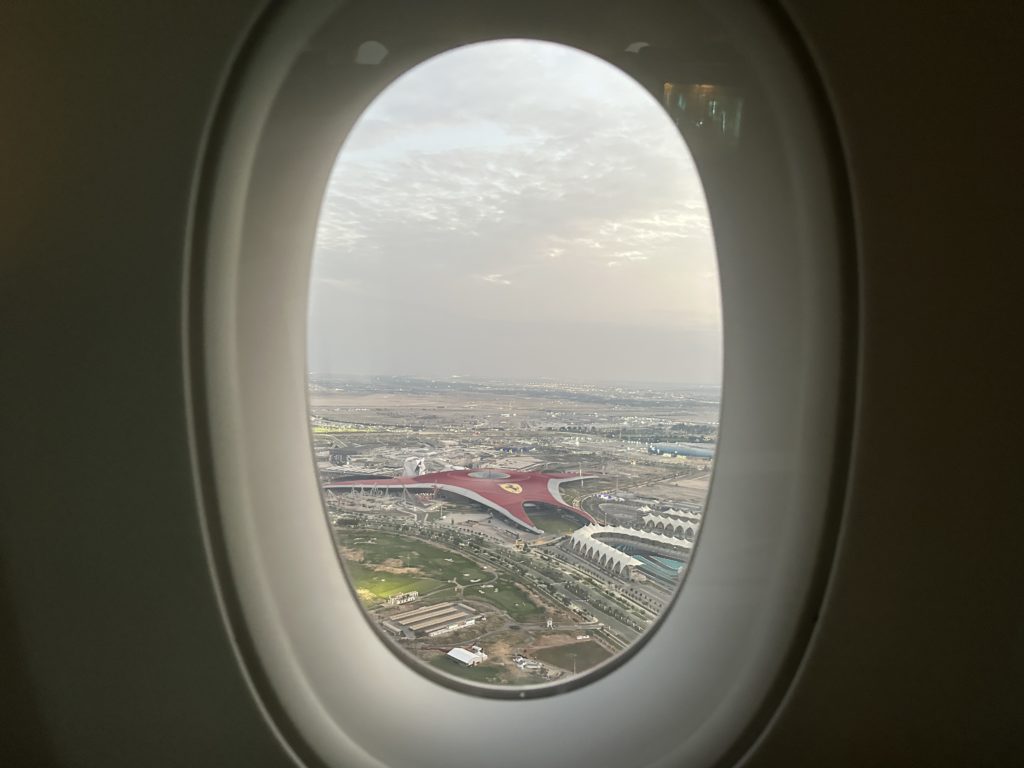 an airplane window with a view of a city and roads