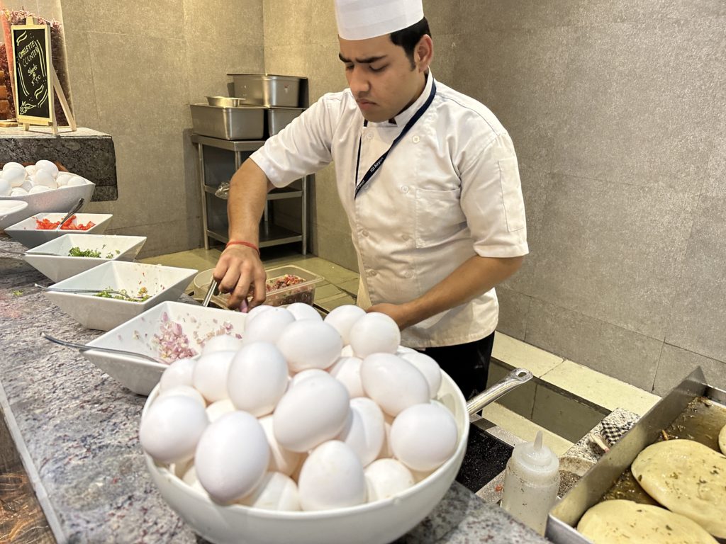 a man in a chef's hat cooking eggs