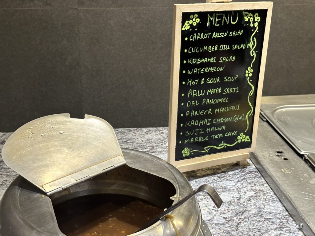 a menu board with a bowl of soup on a table