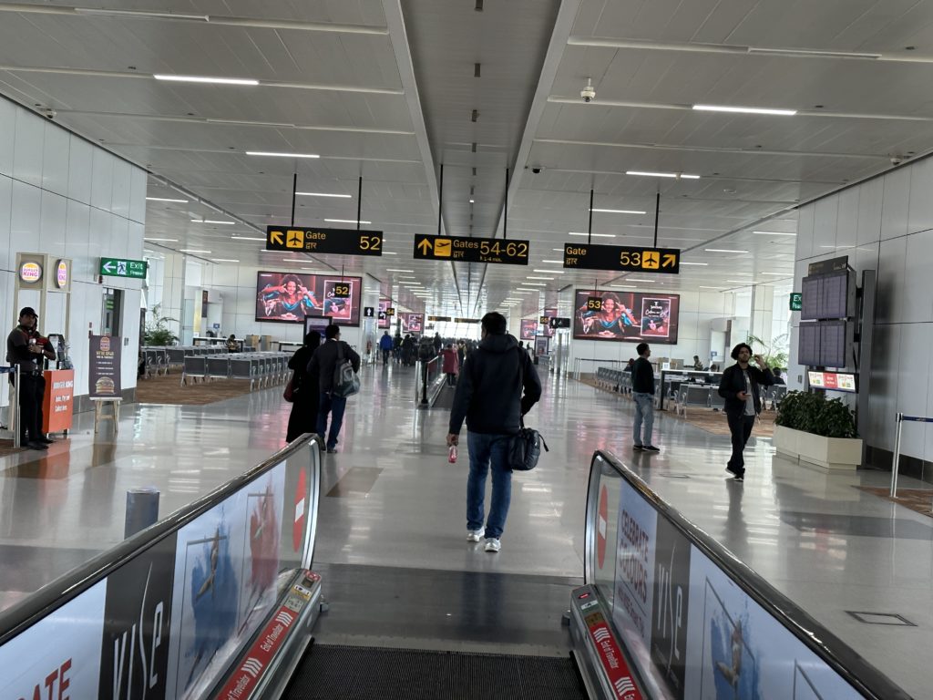 people walking down a walkway in a airport