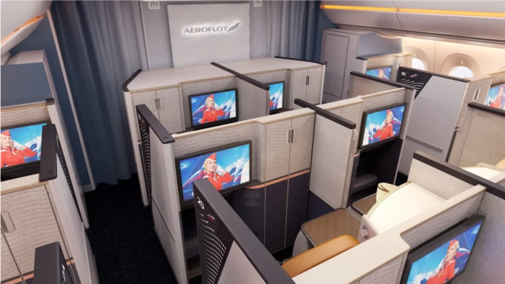 a room with cubicles with tvs and screens