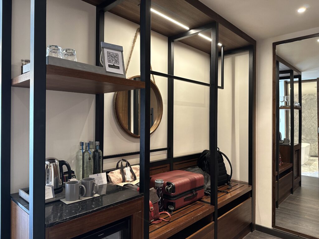 a room with a mirror and a shelf with luggage