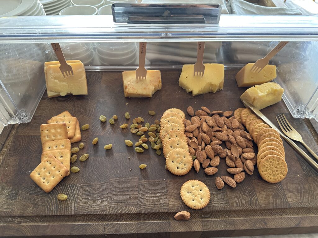 a cheese crackers and nuts on a wooden board