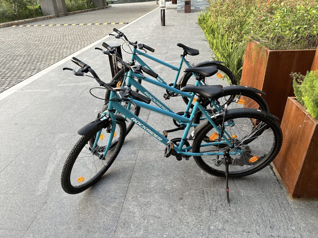 a group of blue bicycles parked on a sidewalk