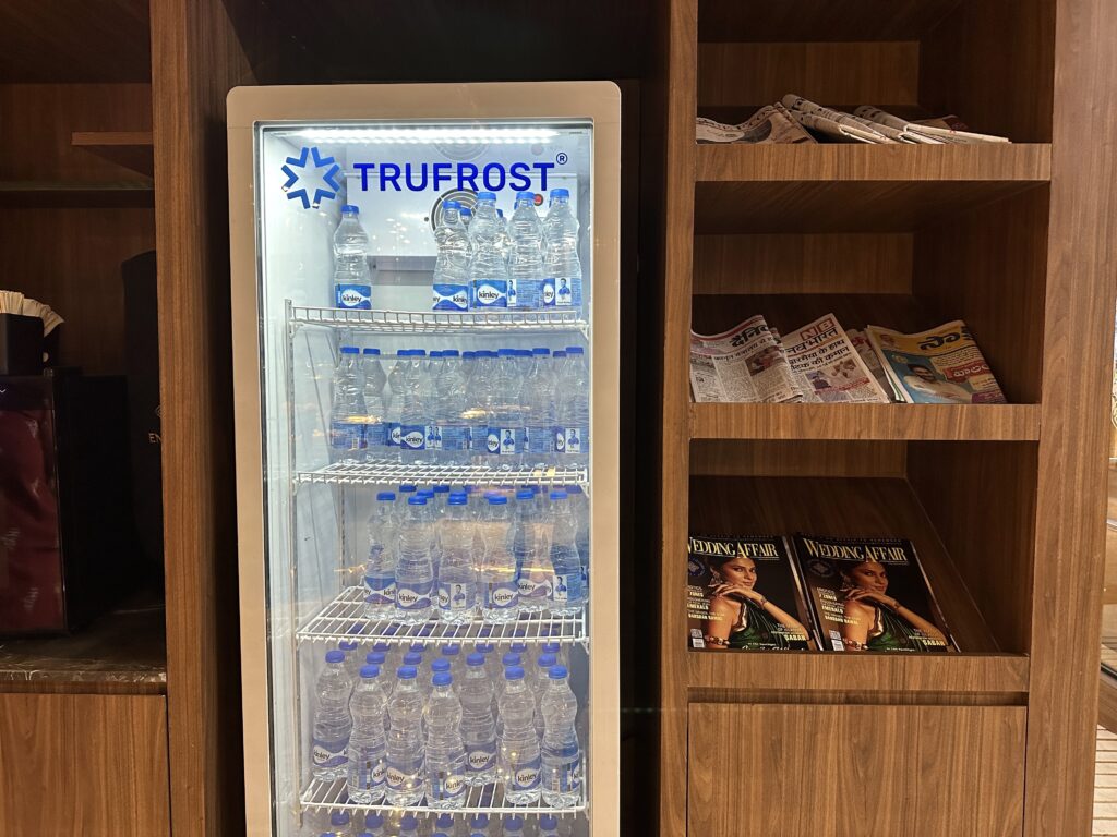 a refrigerator with water bottles and magazines