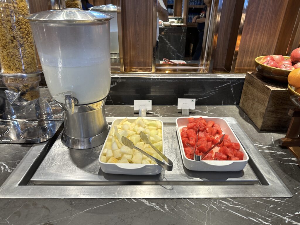 a trays of fruit and a drink dispenser