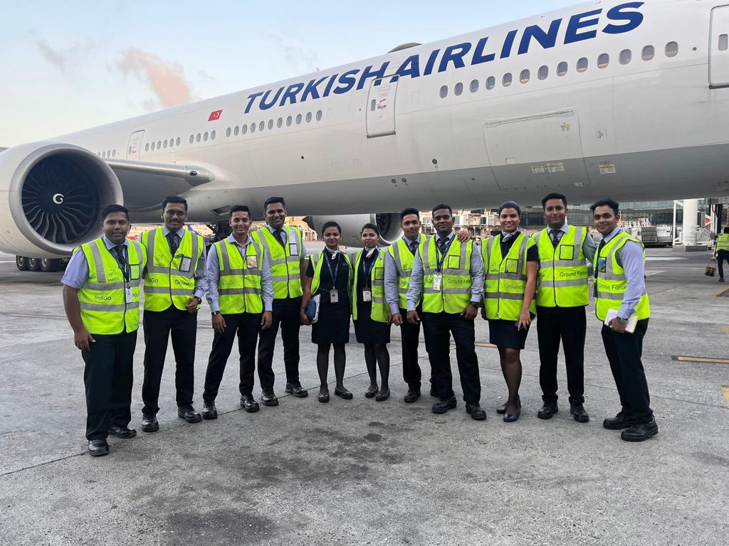 a group of people in reflective vests standing in front of a large airplane