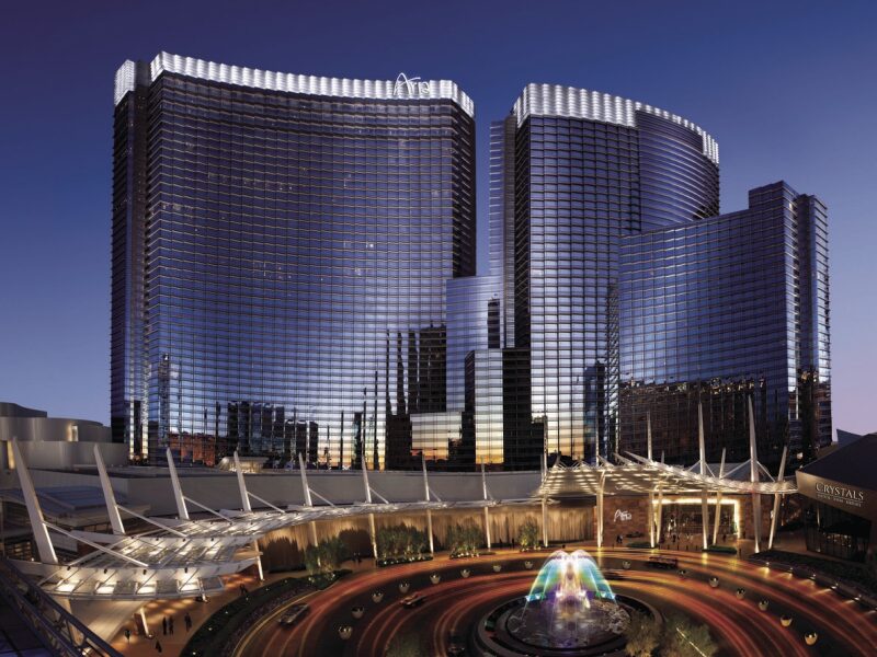a large building with a fountain in front of it with Aria Resort and Casino in the background