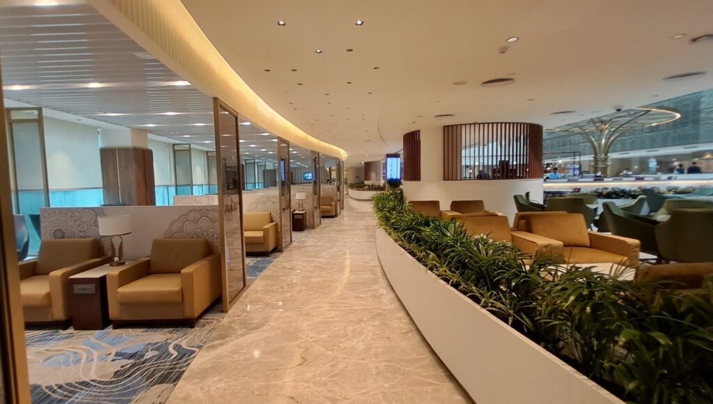 a long hallway with chairs and plants