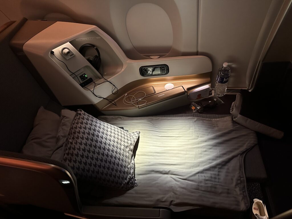 a bed with a pillow and a light on the side of the seat