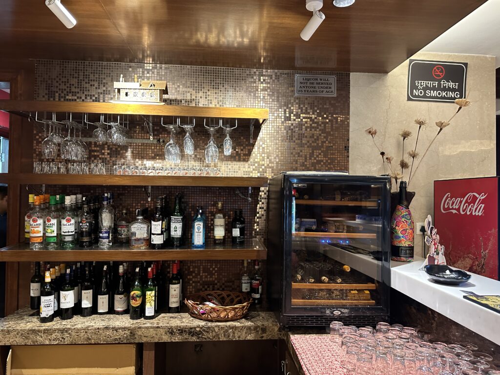 a bar with wine glasses and bottles