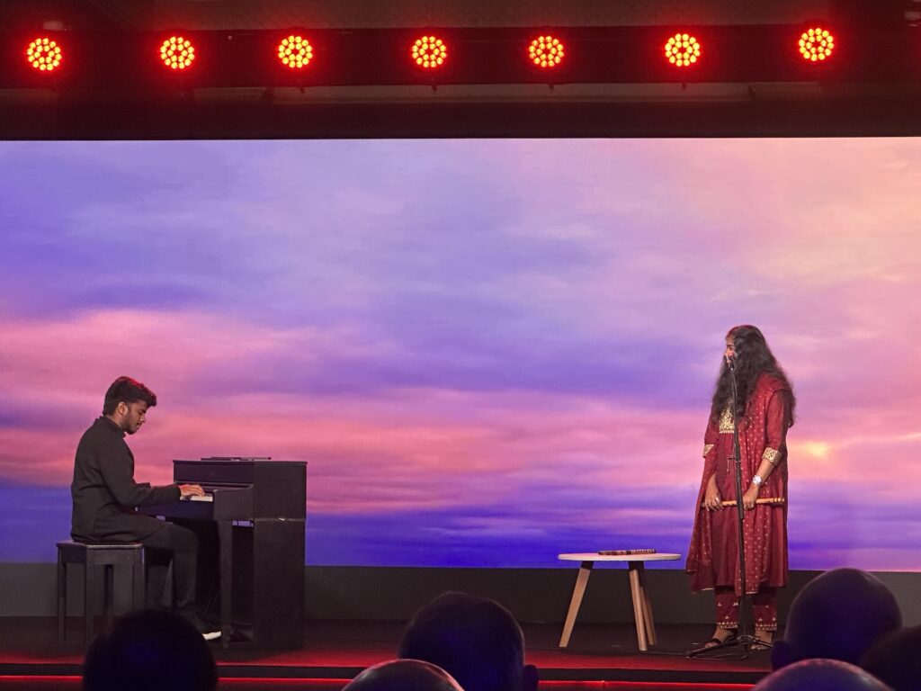 a man playing piano and a woman on stage