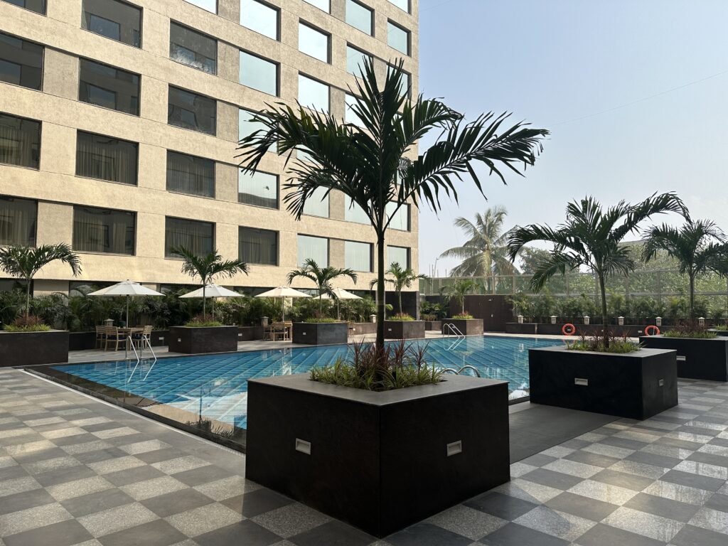 a swimming pool with palm trees and a building