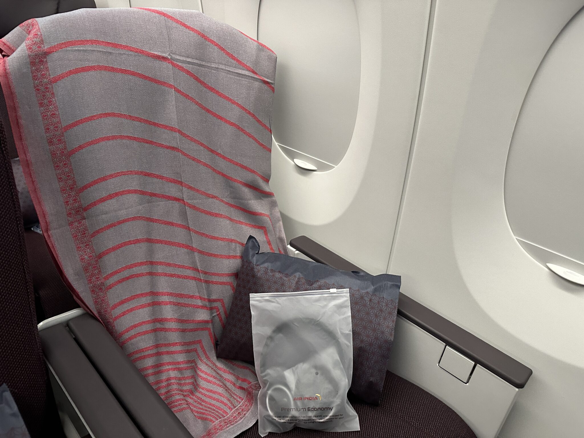 a seat with a blanket and a bag on it