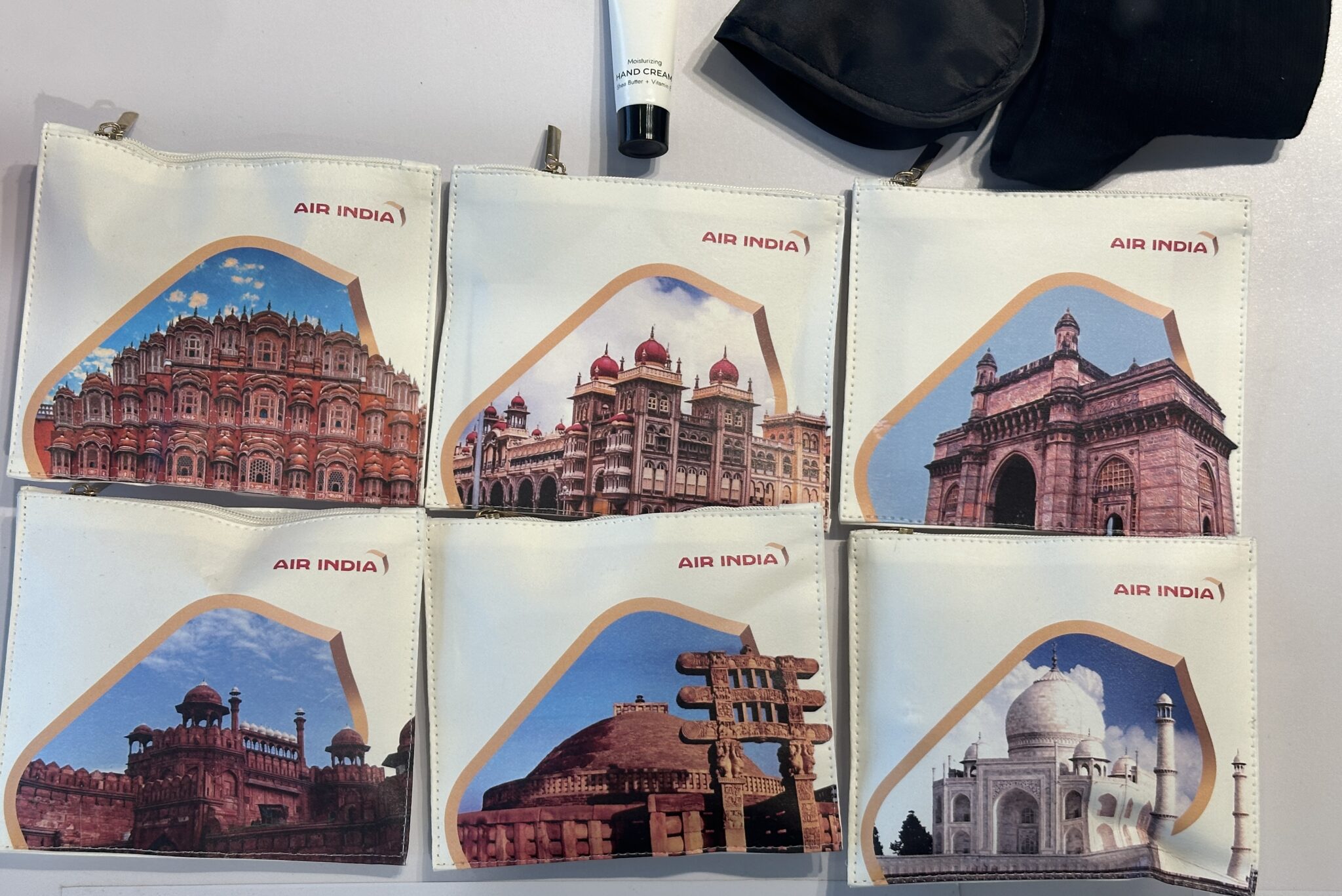 a group of bags with pictures of buildings and a black case