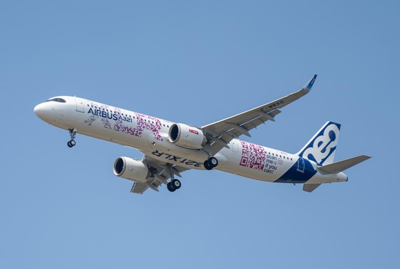 a white and blue airplane flying in the sky