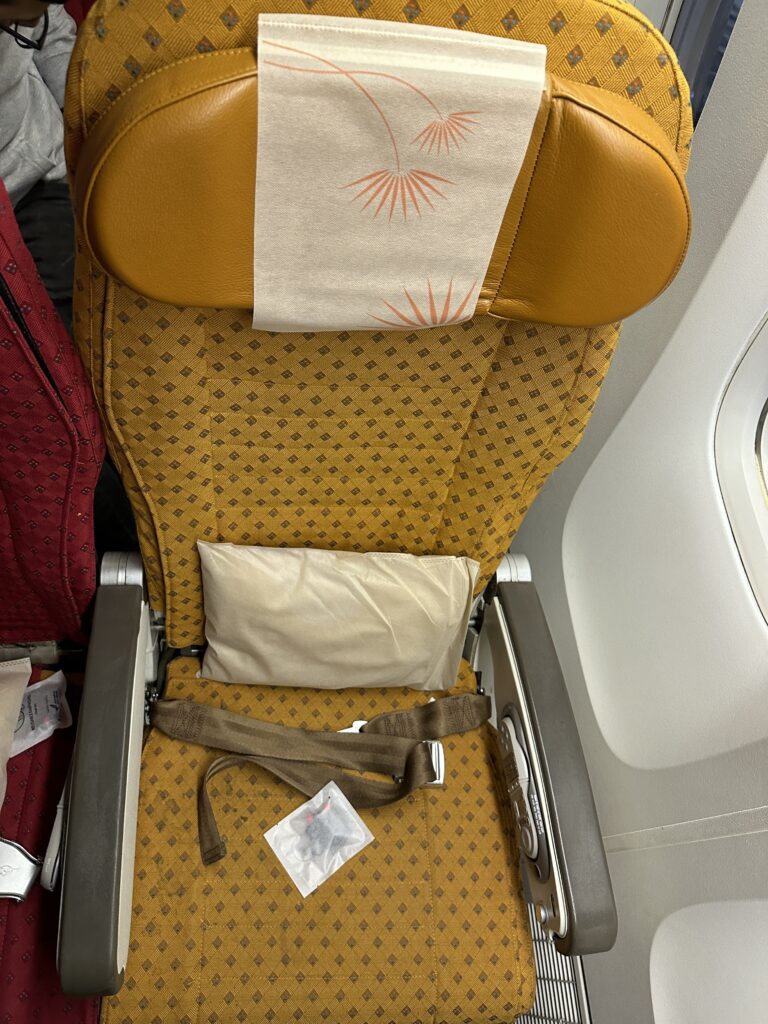a seat with a pillow and a seat belt