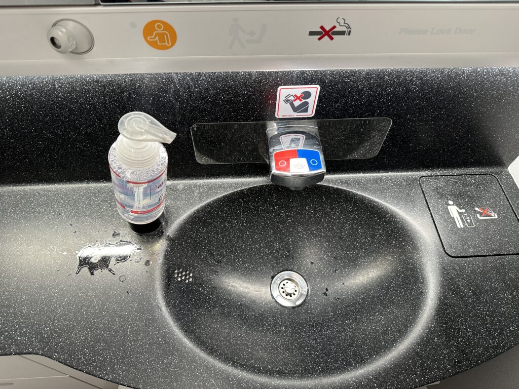 a sink with a bottle of liquid and a bottle of soap