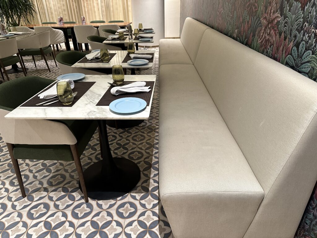 a long white couch and blue plates in a restaurant