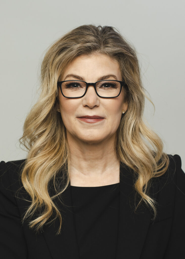 a woman with glasses and a black jacket