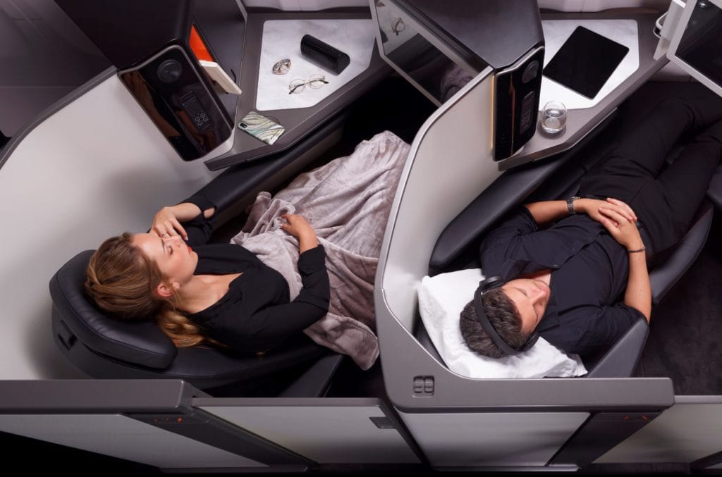 a man and woman sleeping in a plane