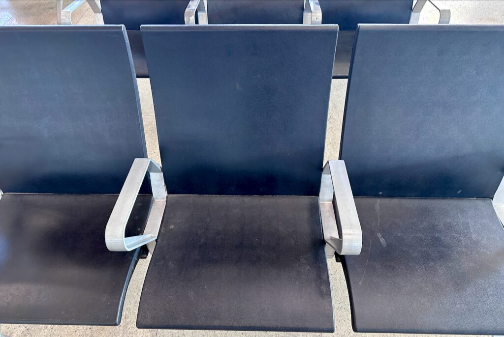 a row of chairs with metal armrests