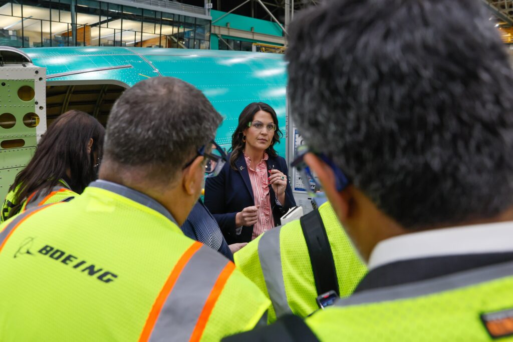 a woman in a suit talking to a group of people