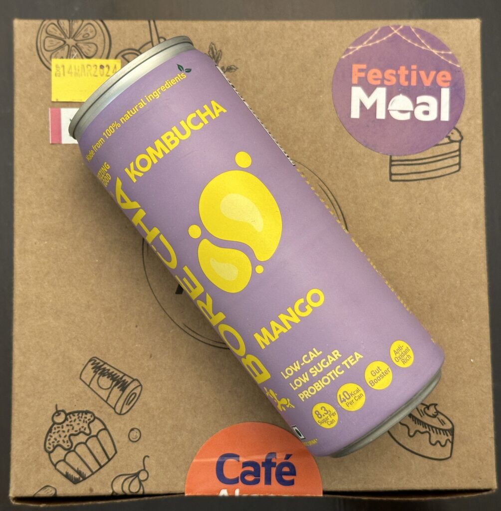 a purple beverage can on a cardboard box