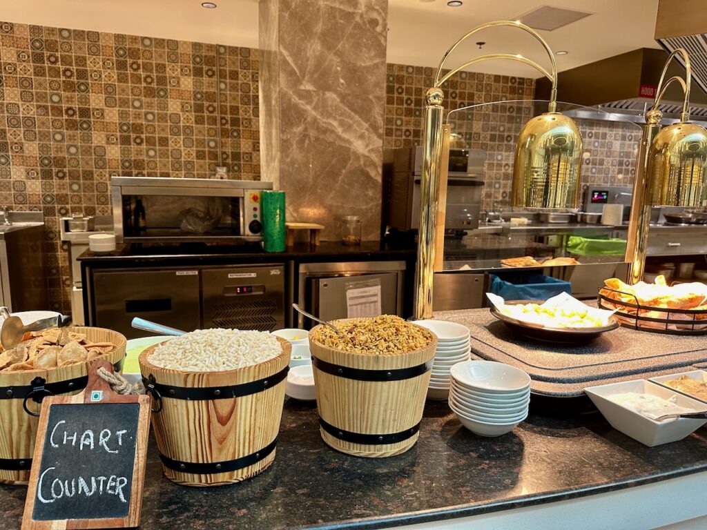 a counter with bowls of food and a sign