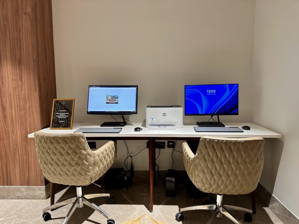 a desk with two computers and a picture frame on it