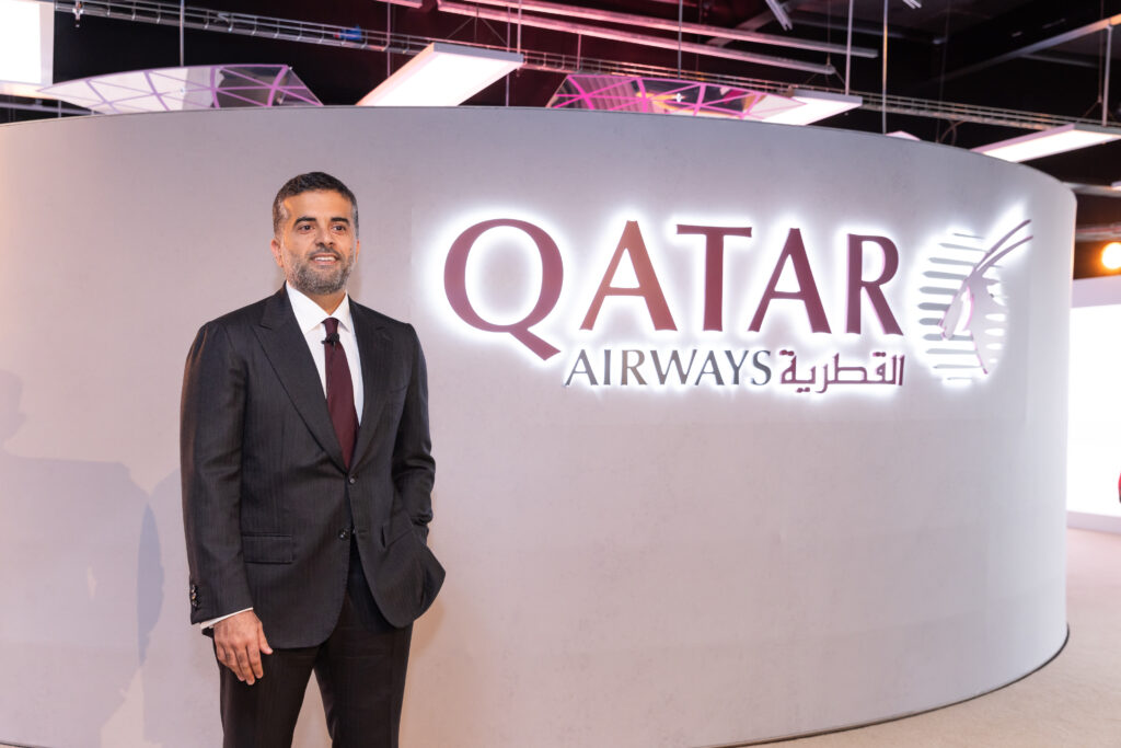 a man in a suit standing in front of a sign