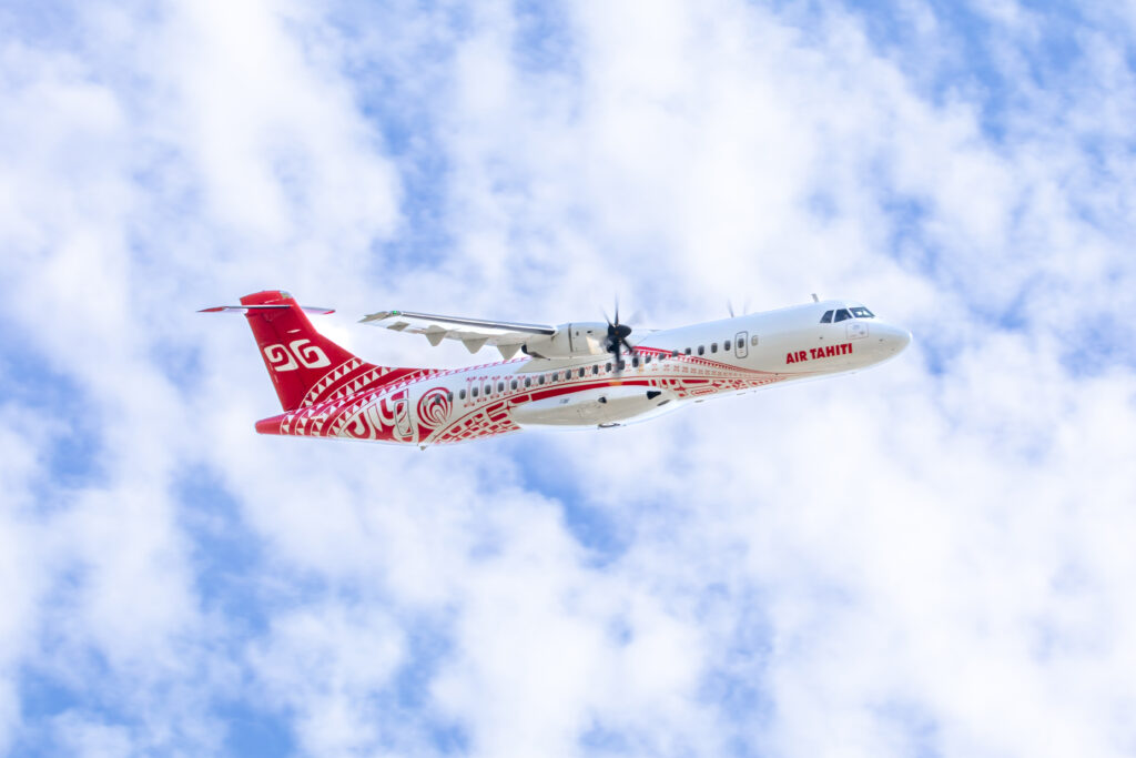 a red and white airplane in the sky