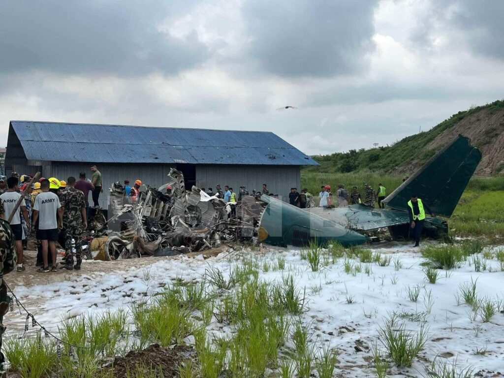 a group of people standing around a crashed plane