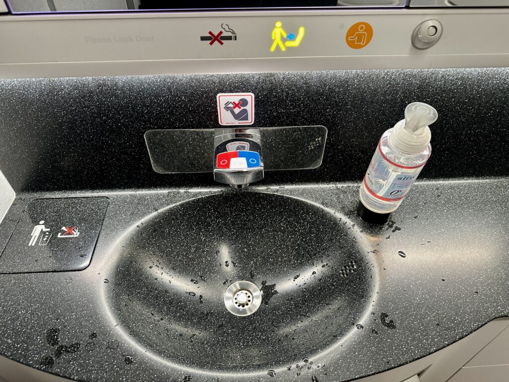 a sink with a bottle of alcohol on it