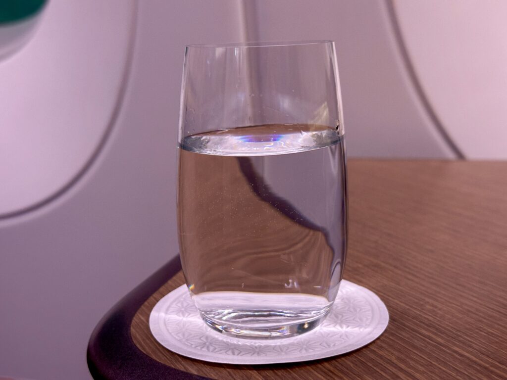 a glass of water on a coaster