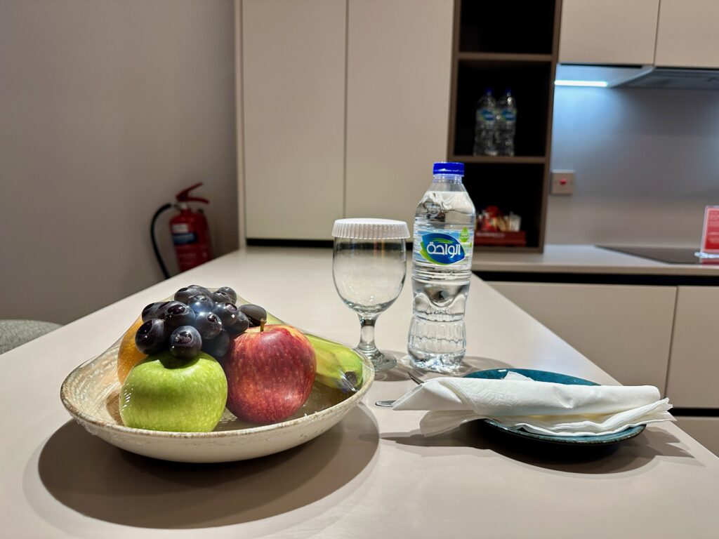 a bowl of fruit and a bottle of water on a table