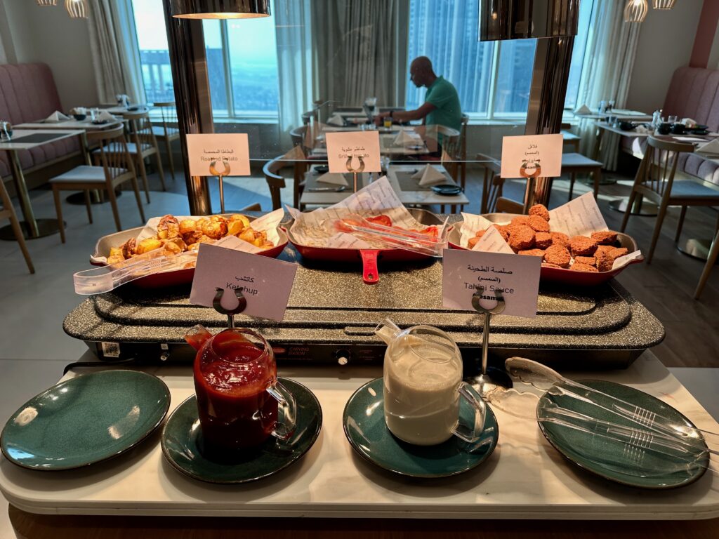 a table with plates of food and plates of sauces