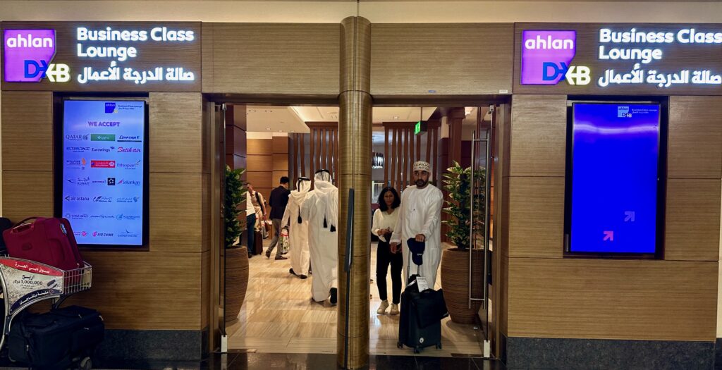 people in white robes and hats standing in front of a glass door