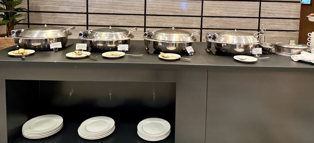 a row of silver pots with lids on a counter