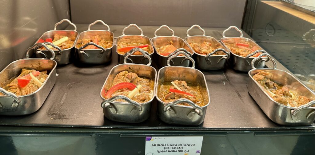 a group of metal containers with food on a table