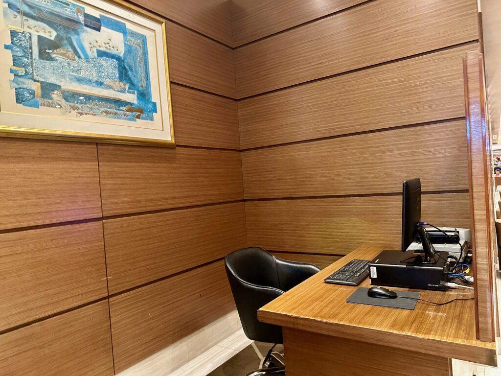 a desk with a computer and a chair in a room with wood panel walls