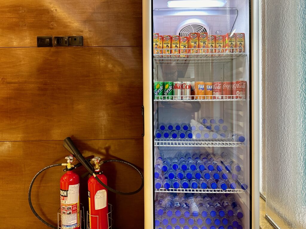 a refrigerator with bottles of soda and fire extinguisher