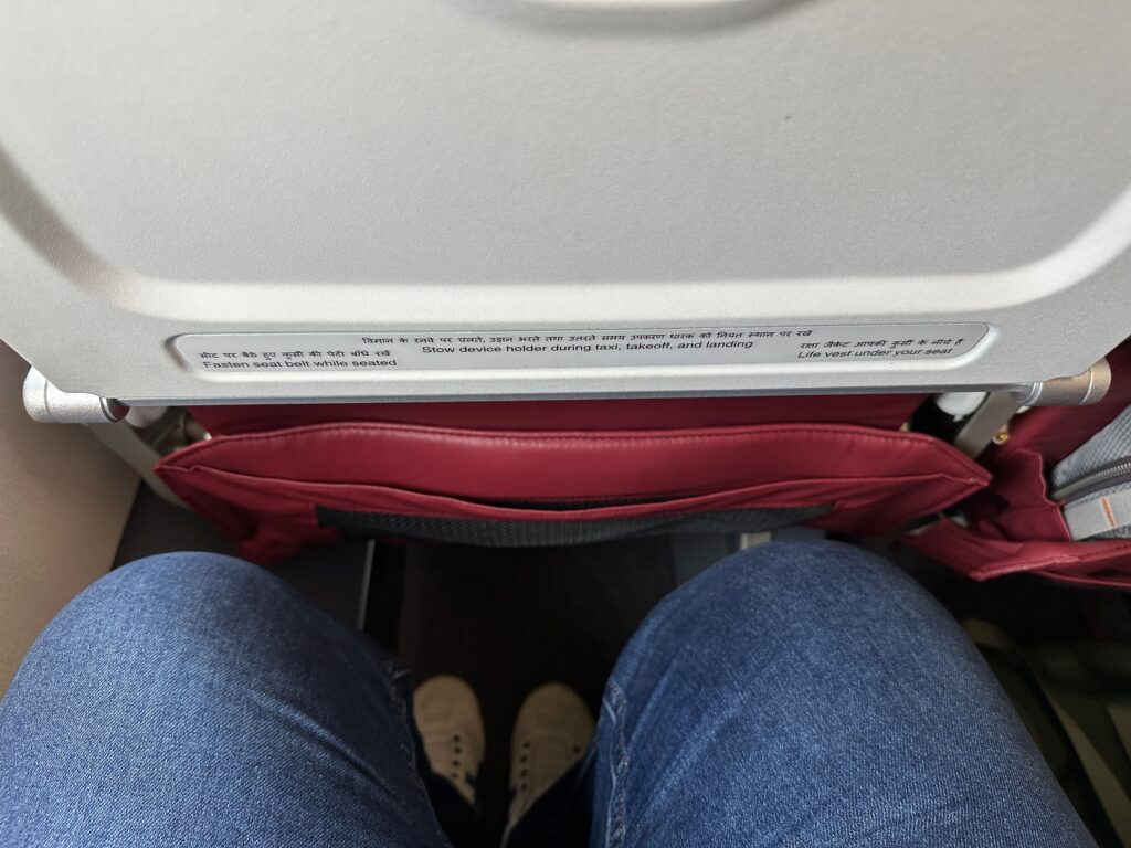 a person's legs and a seat in an airplane