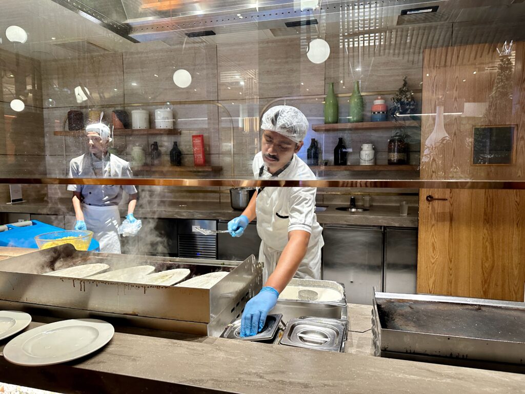 a man wearing white and blue gloves and gloves working in a kitchen