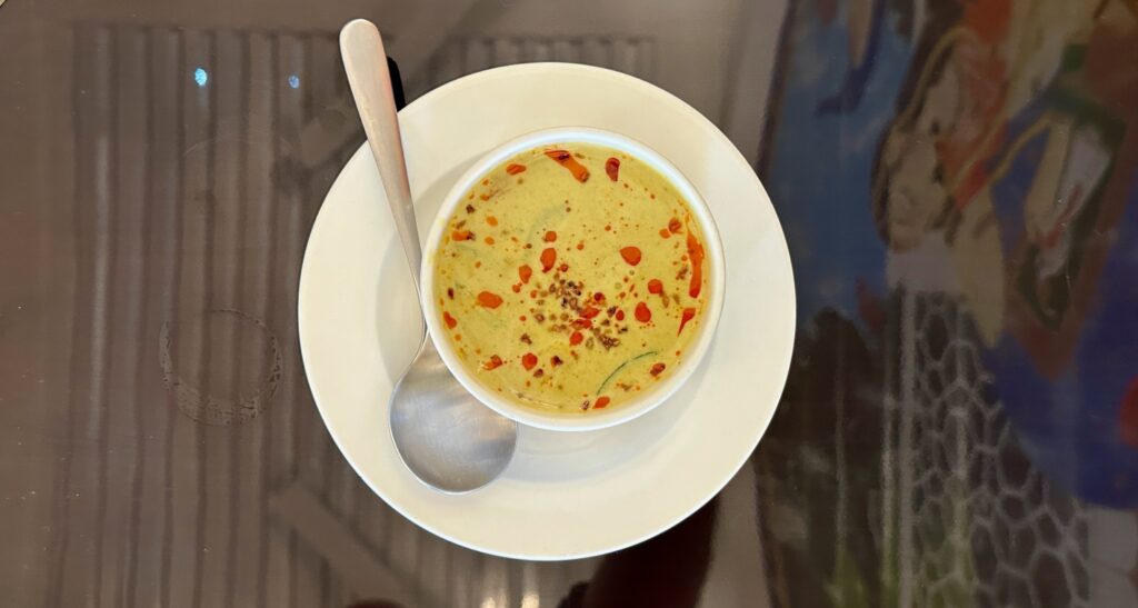 a bowl of soup with a spoon on a plate