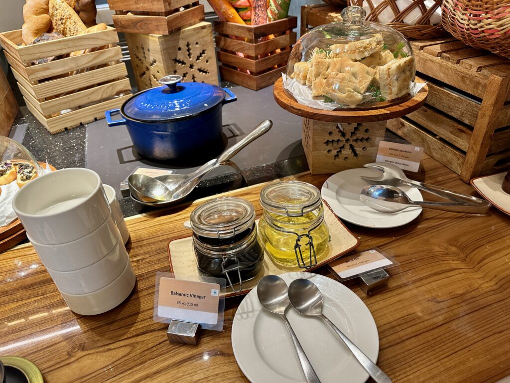 a table with plates and spoons and jars of food