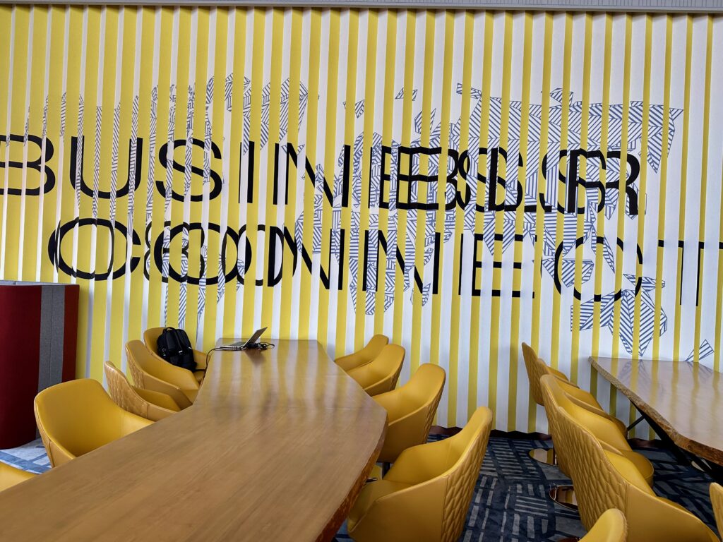 a room with yellow chairs and a long table